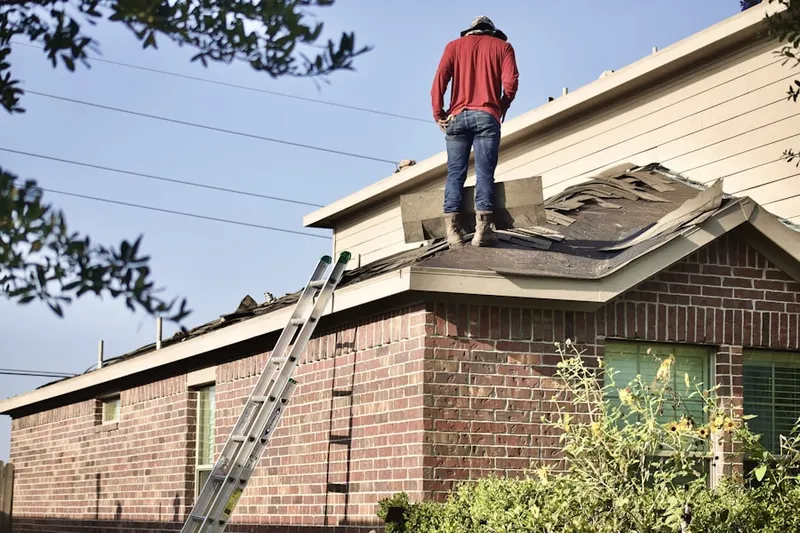 Professional roofer working on a residential roof in Bellflower